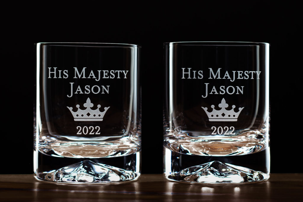 set of whiskey glasses etched with text and a crown